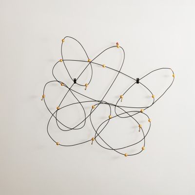 une photo d'une sculpture murale en fil de fer et en verre