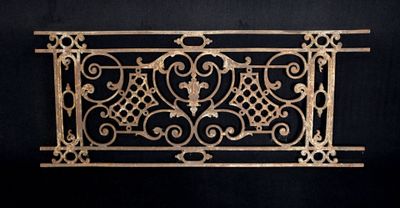 an antique cast iron fireplace grate with scroll design