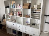 a white bookcase with lots of drawers and plants on top of it