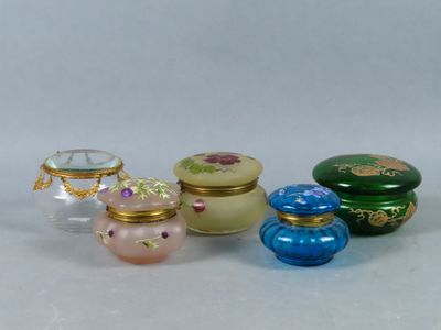 five small glass containers sitting next to each other on a table