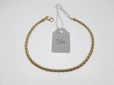 a close up of a gold bracelet with a price tag on it