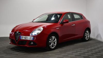 a red car is parked in a room with a checkered floor