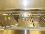 three stainless steel trays are lined up on a counter