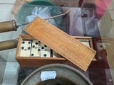 a wooden box with dice pieces in it on a glass table