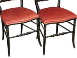 pair of black chairs with red upholstered seats on a white background