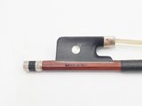 a violin bow and a bow rest on a white surface