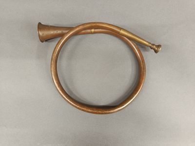 an old brass hose with a brass handle on a gray surface