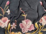 an image of a black purse with pink and yellow flowers on it