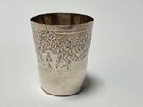 a silver cup with a floral design on it