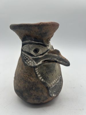 un petit vase orné d'une tête d'oiseau