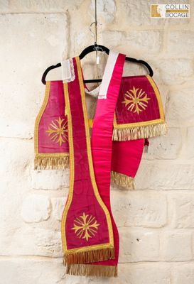 two red and gold vests hanging on a brick wall