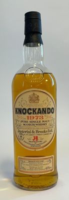 une bouteille de whisky posée sur une surface blanche