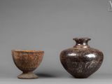 two vases and a bowl sitting next to each other on a gray surface