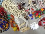 many different types of necklaces and bracelets laid out on a table