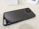 a black cell phone sitting on a table next to a box