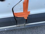 an orange tape on the side of a white car