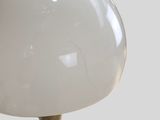 a white lamp that is on a wooden stand
