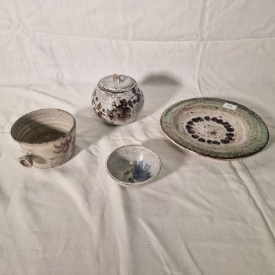 several pieces of pottery sitting on top of a white sheet