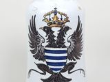 un vase orné d'un blason et d'une couronne