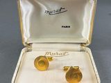 a pair of gold cufflinks in a case