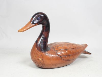 un petit canard en bois posé sur une table