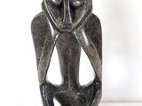 statue d'un homme dont la tête a la forme d'un hibou