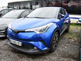 une Toyota C-HR bleue garée devant un bus