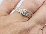 a woman ' s hand with a diamond ring on it