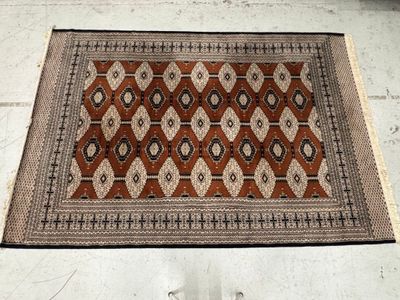 an image of a brown and black rug on a white tiled floor