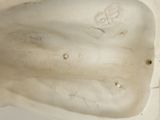 underside view of a white porcelain sculpture of a man ' s head