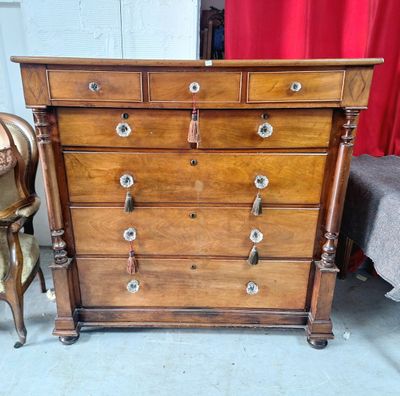 une commode en bois dans une pièce avec un rideau rouge