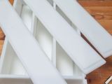 a wooden table with a bunch of white trays on top of it