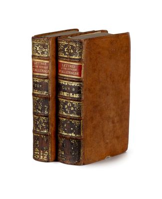 deux vieux livres posés l'un sur l'autre sur une surface blanche