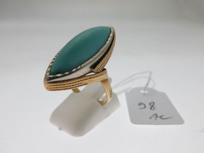gros plan d'une bague sur une surface blanche avec une étiquette de prix