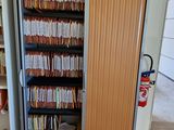 une armoire remplie de dossiers, dans un coin de la pièce