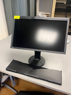 un écran d'ordinateur posé sur un bureau, avec une chaise à côté