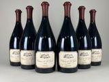 six bottles of wine are lined up in a row