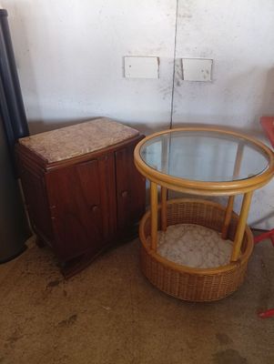 a small table with a glass top and a wicker basket on it