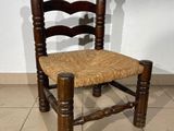 a wooden chair with a woven seat on a tile floor