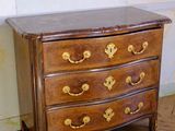 a wooden chest of drawers on a parquet in a room