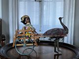 une statue représentant une autruche et une poupée posées sur une table