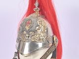 a silver helmet with red hair on top of a mannequin head