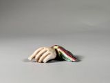 a small figurine of a hand holding a piece of bread