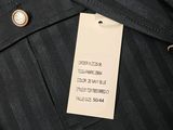 a close up of a label on a black suit with a white tag