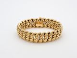 a gold bracelet with a braid design on a white background