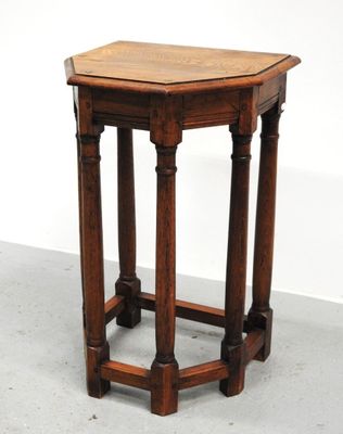 une vieille table en bois avec un plateau en bois, posée sur un sol en ciment