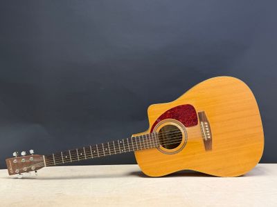 un gros plan d'une guitare posée sur une table, sur fond sombre