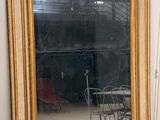 un grand miroir posé par terre à côté d'une chaise