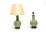 two green vases sitting next to each other on a white surface