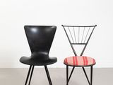 deux chaises noires avec une assise rouge et une chaise noire